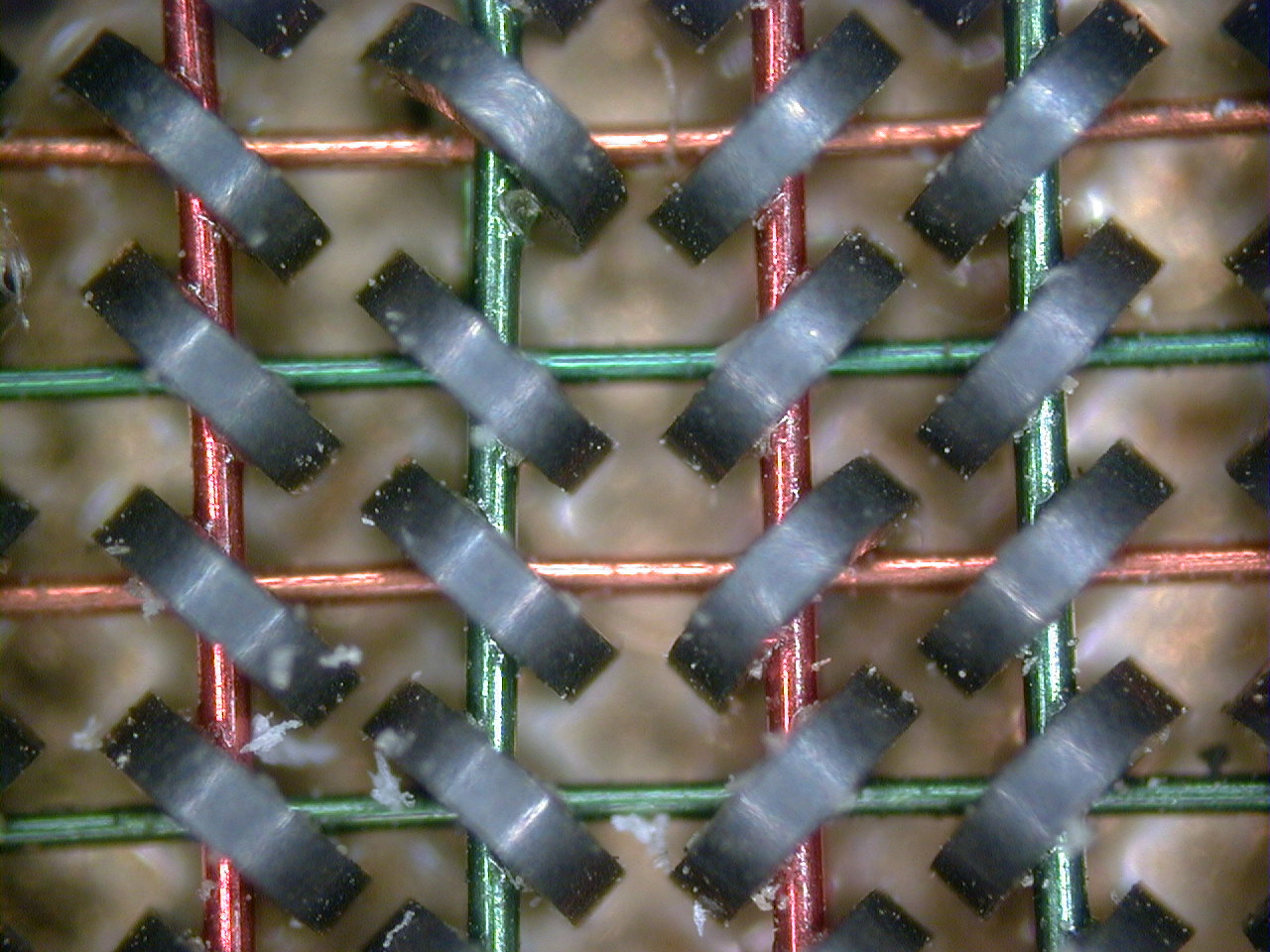 Fifty-times magnified photograph of magnetic core memory showing ferrite rings threaded by crossing wires